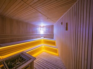 A sauna with wooden walls and benches, a sloped floor, and a skylight. - Balsoy Mountain (Erzurum)