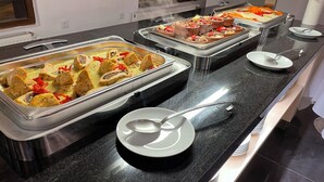 A buffet setup with various dishes in trays, including seafood and vegetables. - Balsoy Mountain (Erzurum)