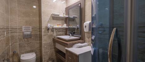 A modern bathroom with a toilet, sink, and shower area.