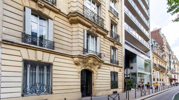 Un bâtiment historique doté de balcons en fer forgé décorés et d’une façade classique.