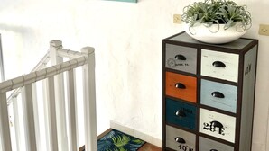 A room with a white crib, a wall-mounted plant, a colorful artwork, and a geometric wall decoration. - Duplex house with garden in the hills above Cagnes  (Cagnes-sur-Mer)