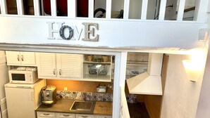 A compact kitchen with white cabinetry, a microwave, a coffee maker, and a sink. - Duplex house with garden in the hills above Cagnes  (Cagnes-sur-Mer)
