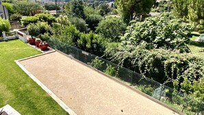 A courtyard with a fenced area, lush greenery, and a view of distant hills and the sea. - Duplex house with garden in the hills above Cagnes  (Cagnes-sur-Mer)