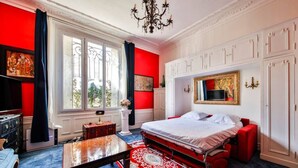 A hotel room with a large bed, a desk, a red carpet, and a view of the outdoors. - #Arc DeTriomphe #Trocadero #Style Haussmanien#AC (Paris)
