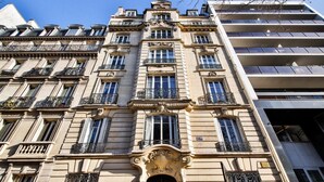 A multi-story building with a classical architectural style, featuring ornate balconies and large windows. - #Arc DeTriomphe #Trocadero #Style Haussmanien#AC (Paris)