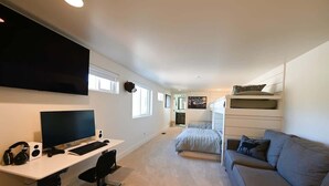 A modern bedroom with a desk, computer, and bunk beds.