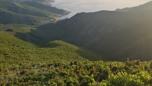 A mountainous landscape with a valley and a body of water.