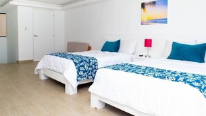 A hotel room with two beds, a white door, a painting of a sunset, and a red lamp. - Villa Marlin, Cancun Caribe, Ocean front (Cancún)