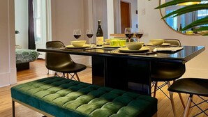 A dining area with a black table, green upholstered bench, and black chairs. - Nice Condo in Limoilou (Quebec City)
