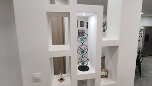 Un intérieur moderne avec un meuble mural blanc doté de nombreuses étagères et d’un élément décoratif central.