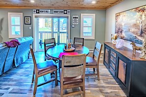 A dining area with a round table, chairs, a bench, and a cabinet with a decorative horse. - Sugar Ski Two Bedroom - Unit 515 (Sugar Mountain)