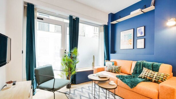 Un salon moderne avec un canapé, un fauteuil et une table basse.