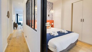 Une chambre d’hôtel avec un grand lit, une armoire, un bureau avec une chaise et une vue par la fenêtre.