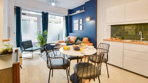 Une cuisine moderne avec un coin repas, comprenant une table ronde, des chaises et un mur d’accent bleu.
