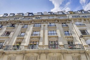 A multi-story building with balconies, large windows, and decorative architectural details. - Confort et élégant, proche du parc des expositions (Paris)