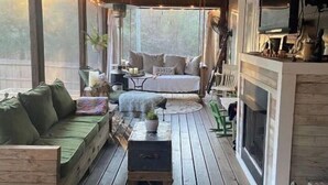 A wooden deck with a sofa, a small table, and a TV mounted on the wall. - 20 min to Bryant Denny Stadium! 5min to public boat landing at Lake Tuscaloosa! (Northport)
