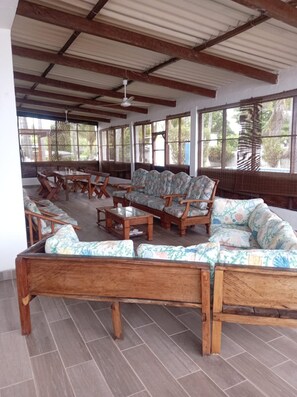A covered outdoor seating area with wooden furniture and a tiled floor. - Private beach front house near International airport, fast Wifi (San Luis Talpa)