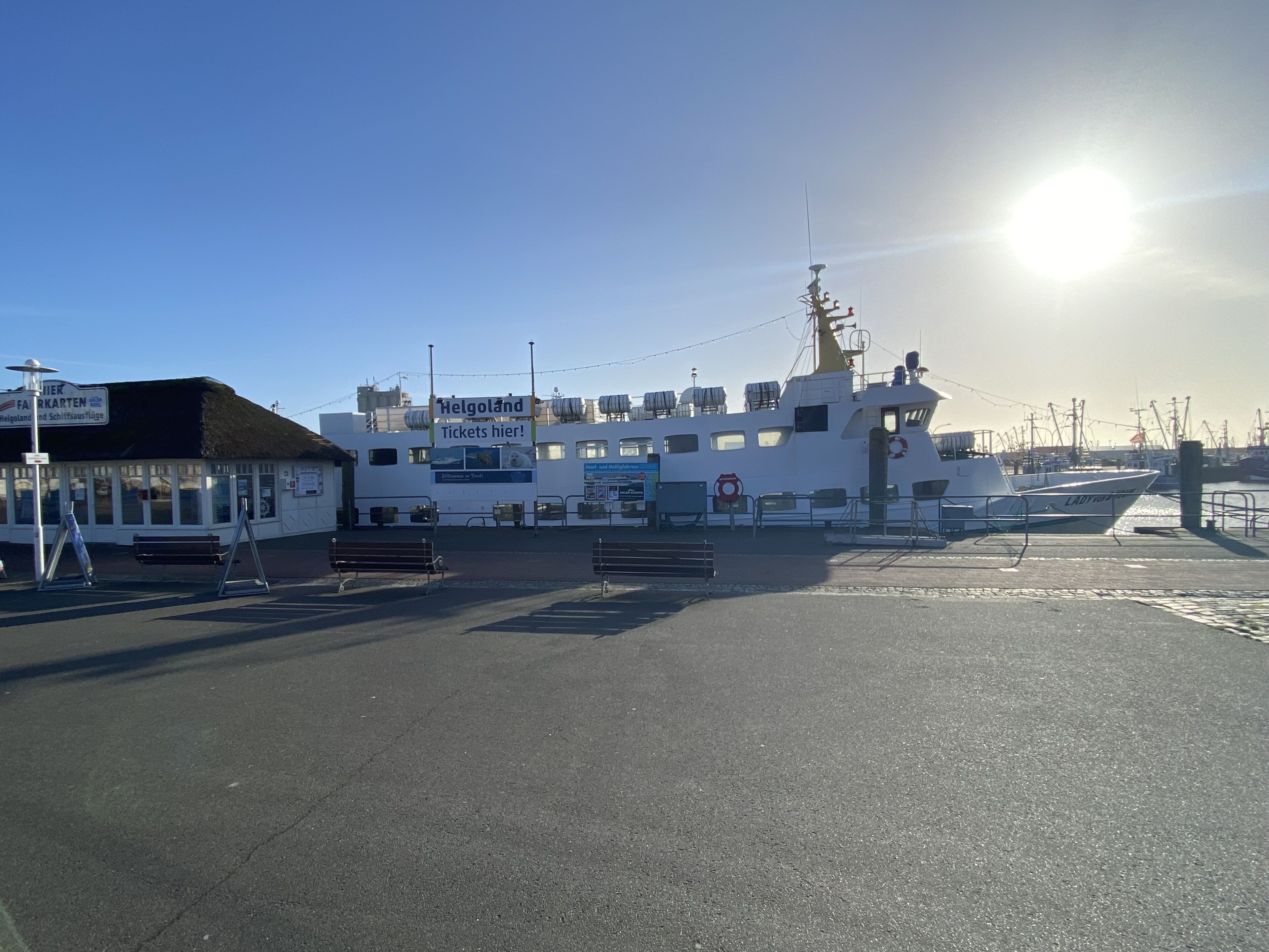 Un quai d’embarquement pour les traversiers, où est amarré un traversier blanc baptisé « Lady of the Isles », et un bâtiment sur lequel on peut lire l’inscription : « Billets ici ! »