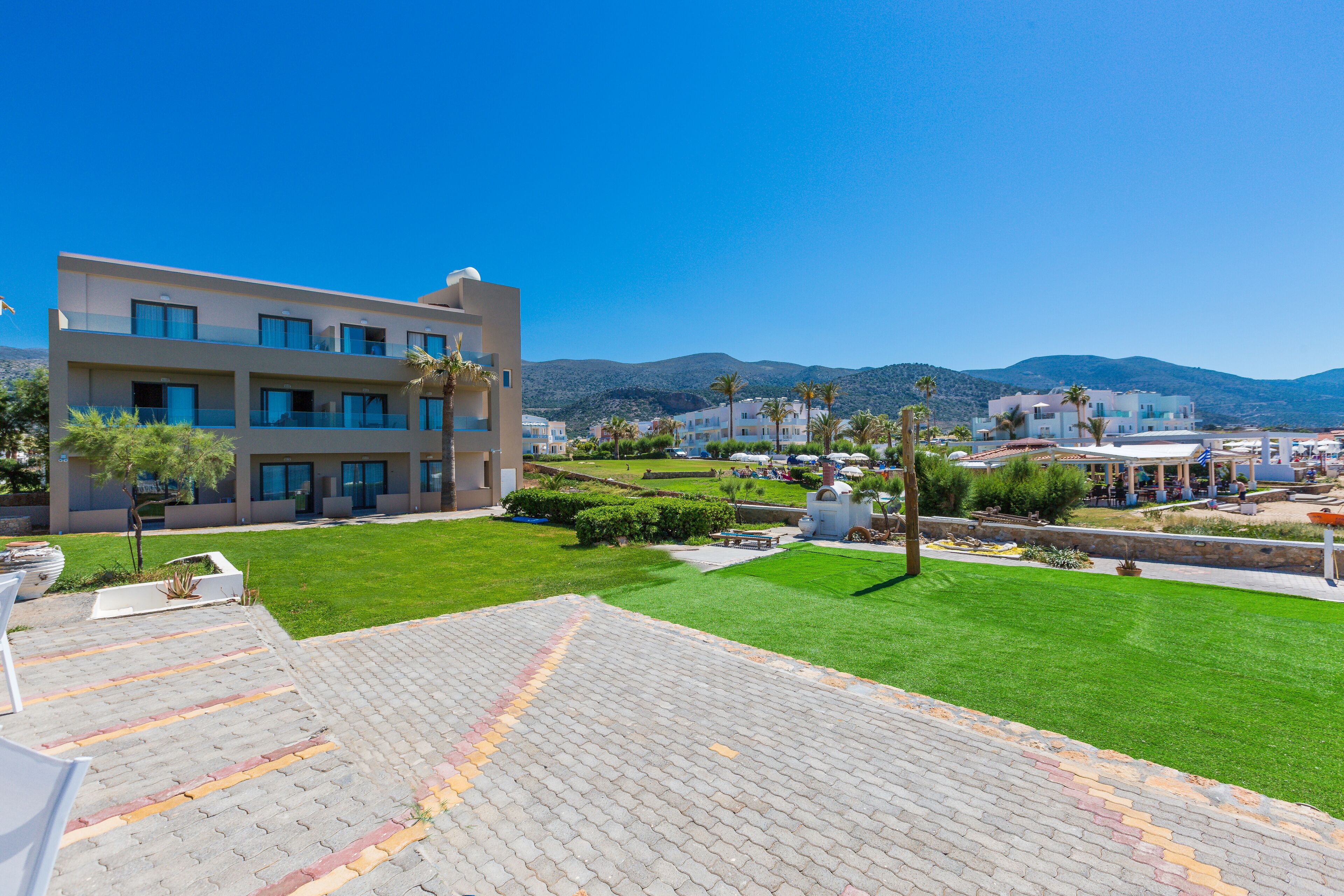 A modern hotel with a courtyard, a pool, and a view of the mountains.