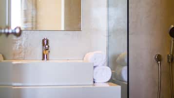 Un baño con lavamanos, espejo y ducha.