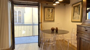 A room with a round table, clear chairs, a wooden cabinet, and two paintings on the wall. - The Old Fashion House (Cortona)