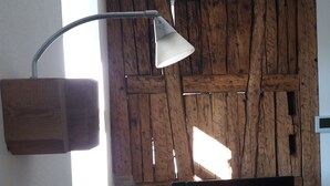 Uma sala de estar moderna com um painel de parede de madeira, uma TV de tela plana e um abajur.