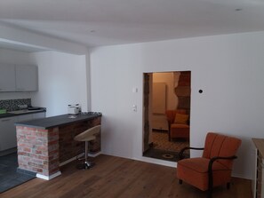 Une cuisine moderne avec un mur d’accent en briques, un coin bar et une chaise de salle à manger.