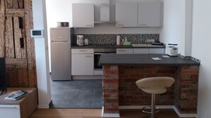 Uma cozinha moderna com armários brancos, cafeteira e parede decorada com tijolos.