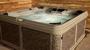 Un bain à remous avec un intérieur en bois, un panneau de commande et une pompe à eau.