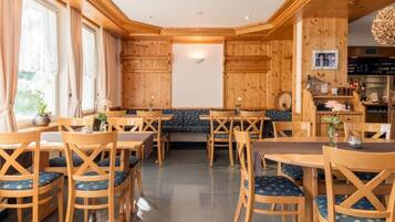Un intérieur en bois avec des tables et des chaises, un banc et un coin bar.