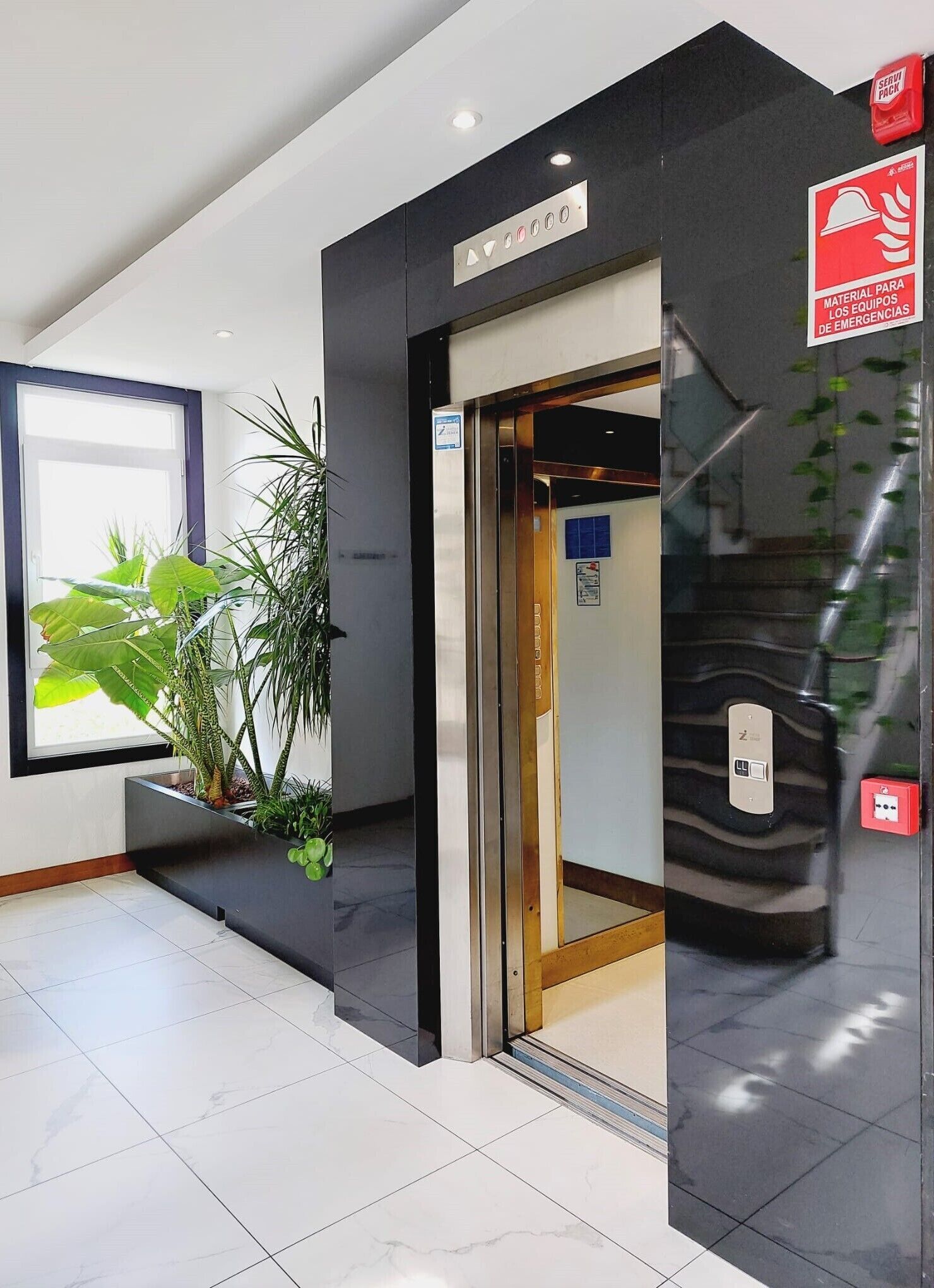 An elevator entrance with a sign indicating emergency equipment material.
