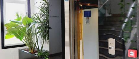 An elevator entrance with a sign indicating emergency equipment material.