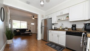 A modern kitchen with white cabinets, stainless steel appliances, and a granite countertop. - 4BR Home, Hot Tub, Near Beach & Wilton Manors (Oakland Park)