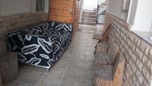 A narrow room with a bed, a wooden wardrobe, a staircase, and a small kitchen area. - Capo first floor (Vodice)