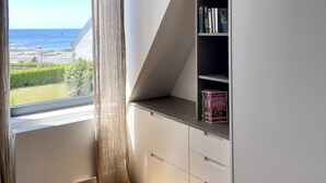 A room with a large window, a bookshelf, and a white cabinet. - Grande Villa, vue Mer, à Bénodet (Bénodet)