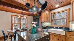 A kitchen with wooden cabinets, a black countertop, and a central island with a vase of flowers.