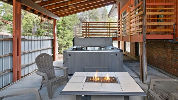 An outdoor patio with a fire pit, seating, and a grill. - Geyser Getaway (West Yellowstone)