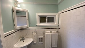 A bathroom with a white sink, a mirror, a window, and a bathtub. - 1 Bedroom Studio and 1 Full Bathroom-Close to Beach, Encore and TD Garden Arena. (Chelsea)