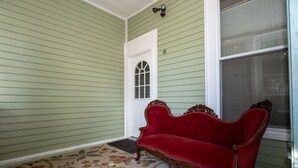 A room with green walls, a white door, a red sofa, and a floral-patterned rug. - 1 Bedroom Studio and 1 Full Bathroom-Close to Beach, Encore and TD Garden Arena. (Chelsea)