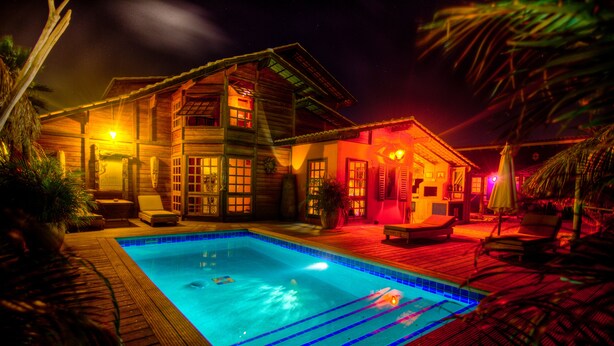 A wooden house with a swimming pool, surrounded by lounge chairs and palm trees. - your favorite hangout on Bonaire (Kralendijk)