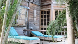 A wooden cabin with a balcony, blue cushioned seating, and a rustic aesthetic. - your favorite hangout on Bonaire (Kralendijk)