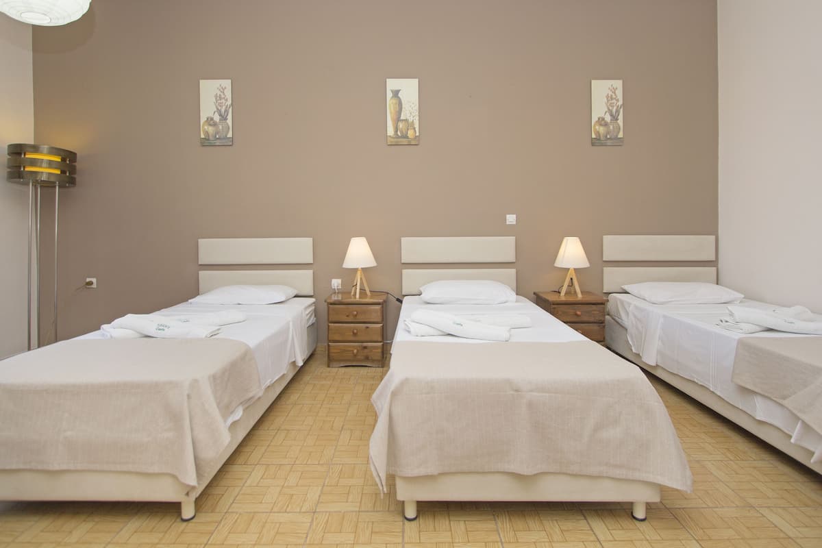 Ein Hotelzimmer mit zwei Einzelbetten, einem Nachttisch mit Lampe und einem Wandbild.