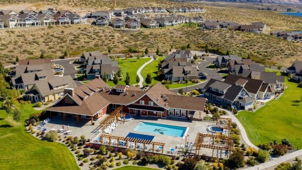 Zona residencial con casas, piscina y césped cuidado.