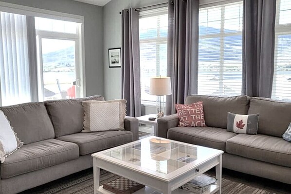 A living room with two sofas, a coffee table, and a lamp. - Lake View Cottage #212 (Osoyoos)