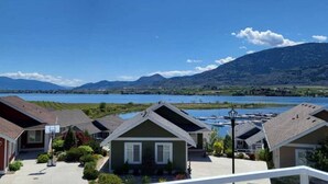 Zona residencial con casas, un lago y montañas al fondo.