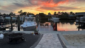 A marina with boats docked, a wooden deck, and a sunset in the background. - Adorable Waterfront guest house (Apollo Beach)