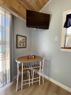 Enjoy a warm and inviting space with a flat-screen TV, round table, and comfortable seating for two.