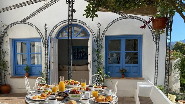 A round table with breakfast items, blue doors, and white walls. - Amazing 6 bed villa with private pool and views (Almuñecar)