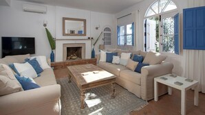 A living room with a fireplace, sofas, a coffee table, and a TV. - Amazing 6 bed villa with private pool and views (Almuñecar)