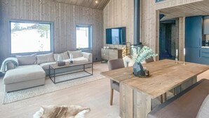 A modern living room with a sofa, coffee table, and a wooden dining table. - Awesome home in Hønefoss with WiFi (Hønefoss)